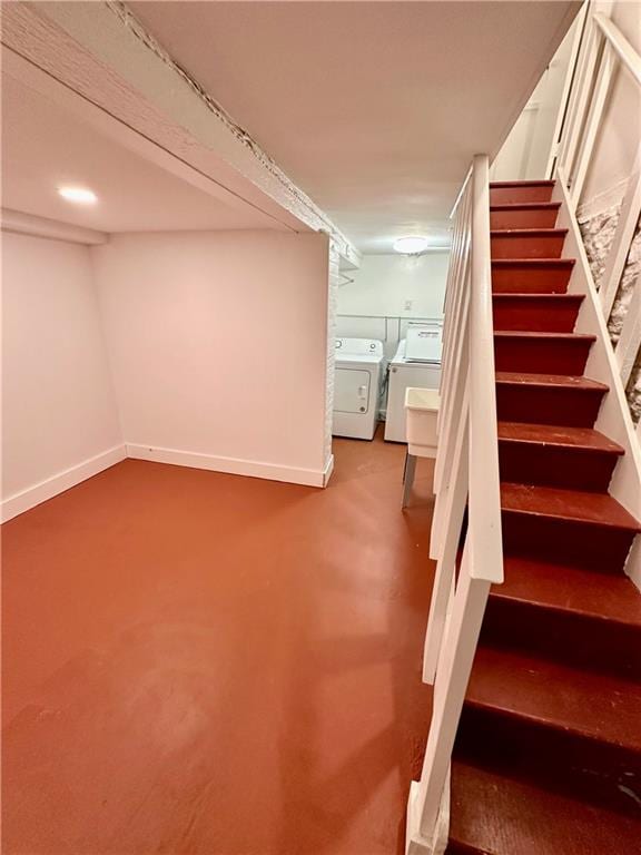 finished below grade area featuring stairway, independent washer and dryer, and baseboards