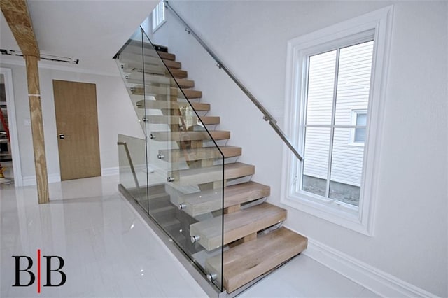 stairway featuring baseboards and tile patterned flooring