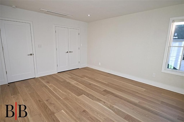 unfurnished bedroom with light wood-style flooring and baseboards