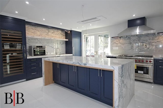 kitchen featuring wine cooler, a large island, wall chimney exhaust hood, blue cabinets, and appliances with stainless steel finishes