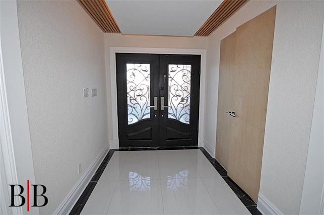 doorway to outside with french doors, baseboards, and tile patterned floors