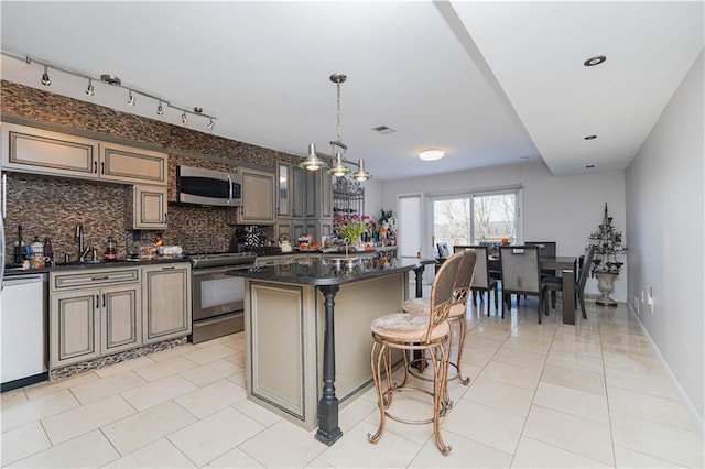 kitchen featuring a sink, visible vents, appliances with stainless steel finishes, tasteful backsplash, and dark countertops