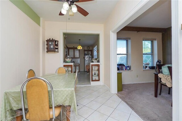 dining space featuring ceiling fan and light colored carpet