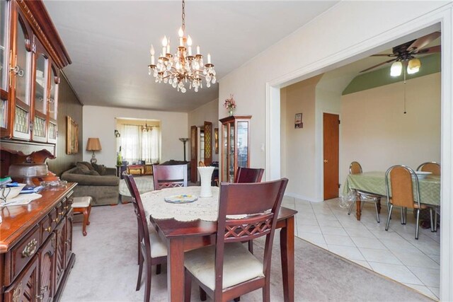 dining room with light tile patterned floors and ceiling fan with notable chandelier