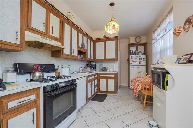 kitchen featuring light tile patterned flooring, pendant lighting, backsplash, and white appliances