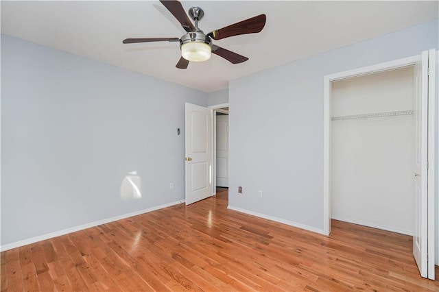 unfurnished bedroom featuring a closet, light wood-type flooring, a ceiling fan, and baseboards