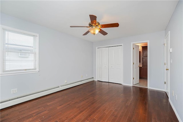 unfurnished bedroom featuring a baseboard radiator, wood finished floors, a ceiling fan, baseboards, and a closet