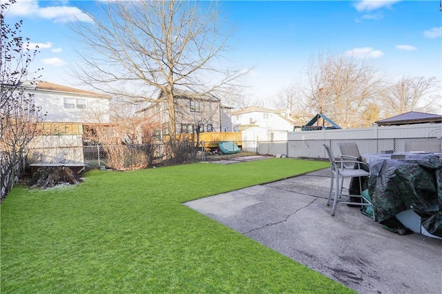 view of yard with a fenced backyard, a patio, and a playground