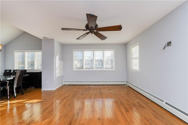 unfurnished living room featuring baseboards, baseboard heating, light wood-style flooring, and a ceiling fan