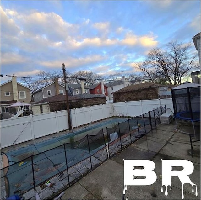 pool at dusk with a trampoline