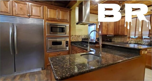 kitchen featuring built in appliances, a kitchen island with sink, island exhaust hood, and sink