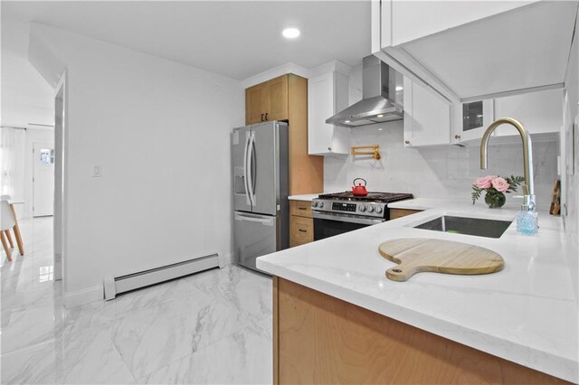 kitchen with white cabinetry, stainless steel appliances, a baseboard radiator, wall chimney exhaust hood, and sink