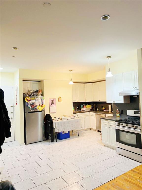 kitchen with stainless steel appliances, decorative light fixtures, white cabinetry, and tasteful backsplash