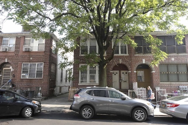 view of property featuring brick siding and cooling unit