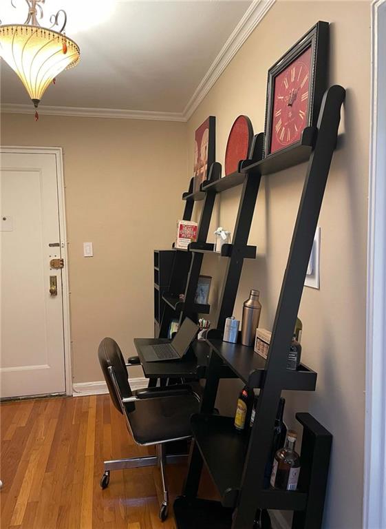 home office featuring light hardwood / wood-style floors and crown molding