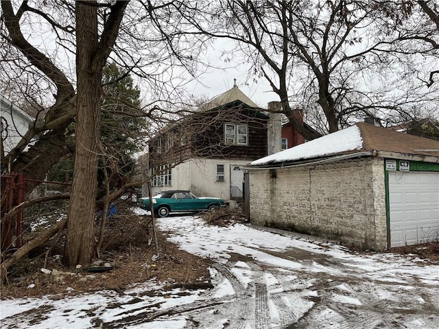 view of snowy exterior featuring a garage