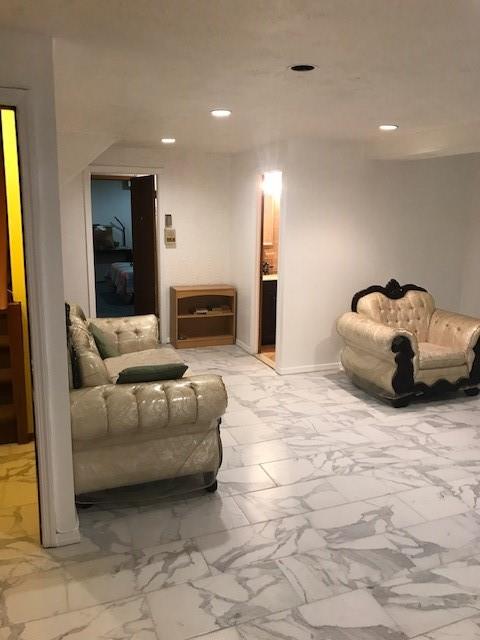 living area featuring recessed lighting, baseboards, and marble finish floor