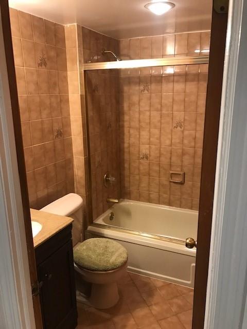 bathroom with vanity, tile patterned floors, toilet, and washtub / shower combination