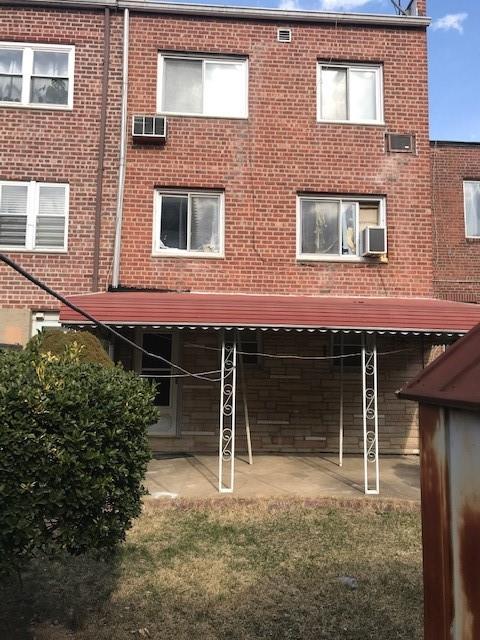 rear view of house featuring a patio, brick siding, and a wall mounted AC