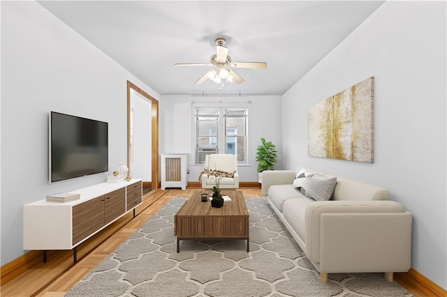 living room with light hardwood / wood-style floors and ceiling fan