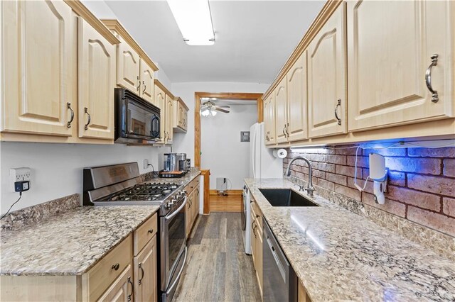 kitchen with sink, light brown cabinets, dark hardwood / wood-style floors, stainless steel appliances, and light stone countertops