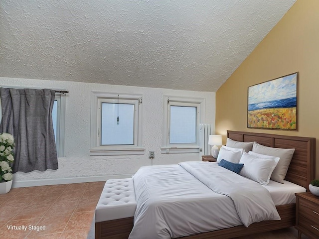 bedroom featuring lofted ceiling, tile patterned flooring, and a textured ceiling