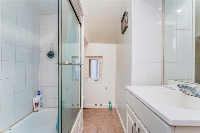 bathroom with tile patterned flooring, vanity, and bath / shower combo with glass door