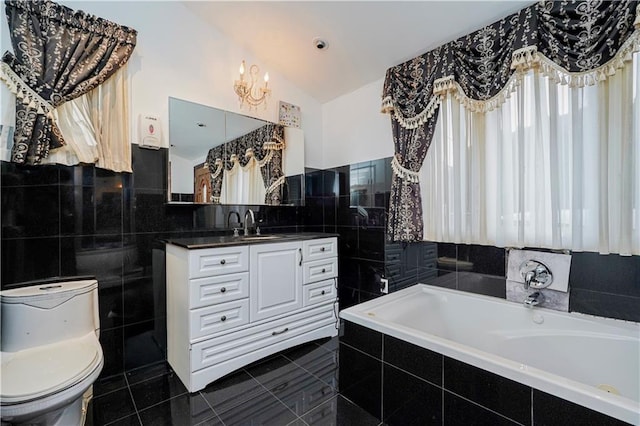 bathroom with toilet, vaulted ceiling, tile walls, vanity, and tile patterned flooring