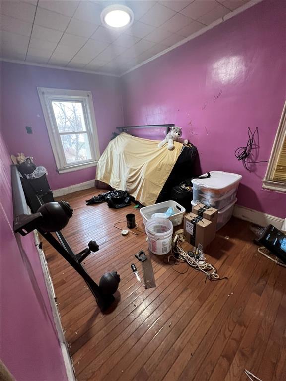 bedroom featuring ornamental molding and hardwood / wood-style floors