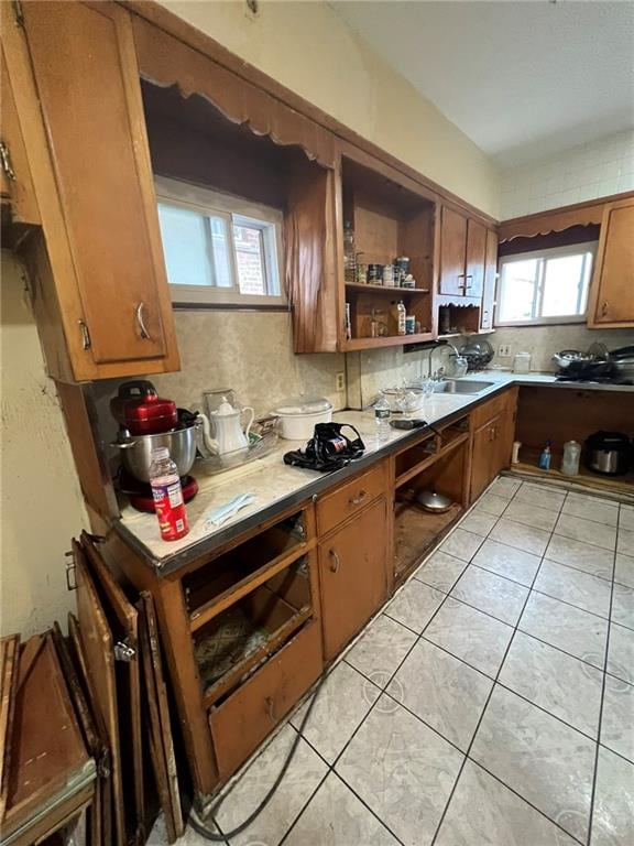 kitchen with sink, light tile patterned flooring, and decorative backsplash