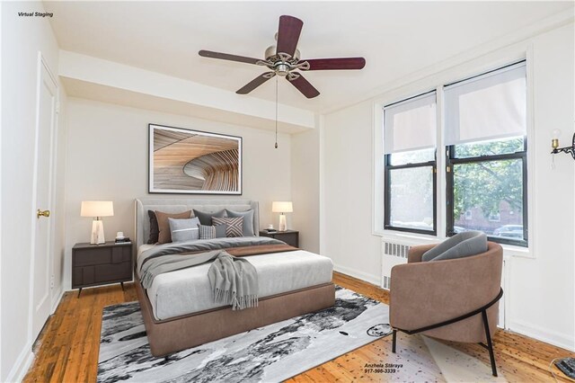 bedroom featuring ceiling fan, hardwood / wood-style floors, and radiator