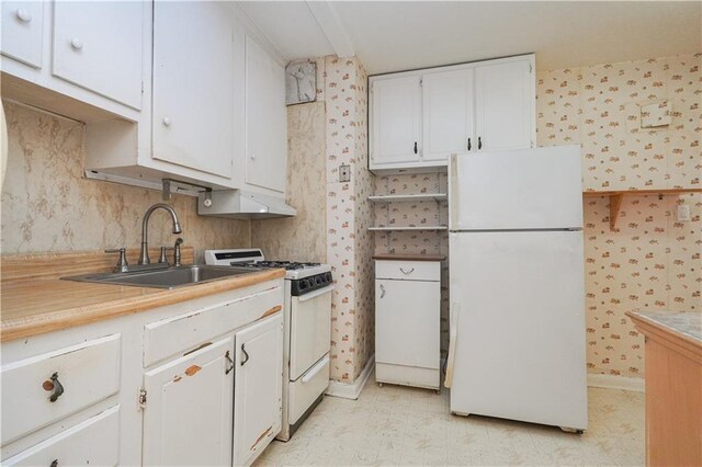 kitchen with sink, white appliances, and white cabinets