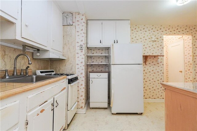 kitchen featuring sink, white cabinets, and white appliances