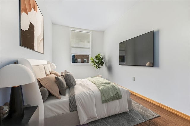 bedroom with baseboards and wood finished floors