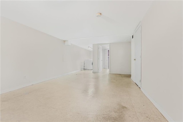 unfurnished room featuring baseboards and washer / dryer