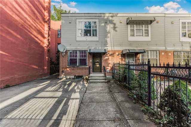 view of front of property featuring fence and brick siding