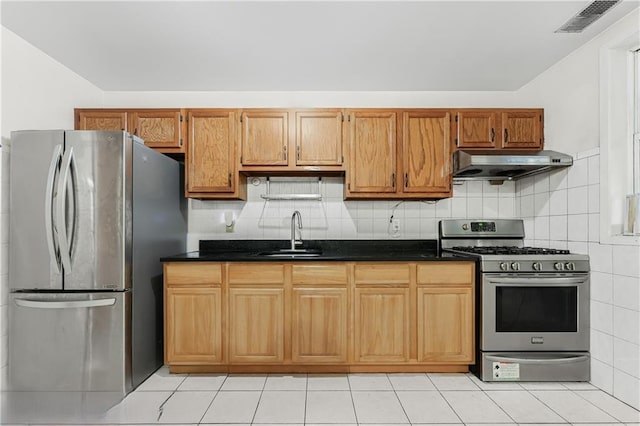 kitchen with a sink, stainless steel appliances, light tile patterned floors, under cabinet range hood, and visible vents
