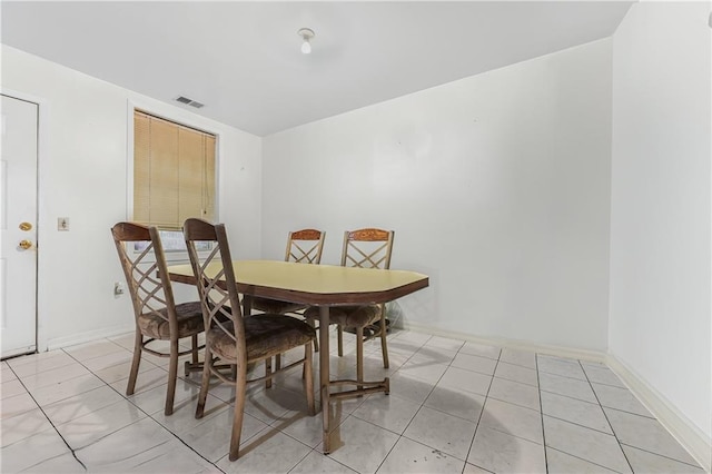 dining room with baseboards, light tile patterned flooring, and visible vents