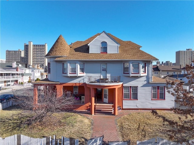 victorian house with fence and roof with shingles