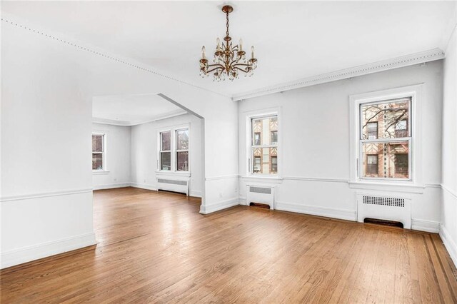 unfurnished dining area featuring plenty of natural light and radiator heating unit