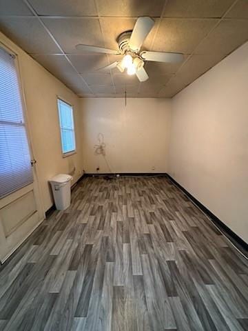 unfurnished room featuring ceiling fan, a paneled ceiling, and dark hardwood / wood-style flooring