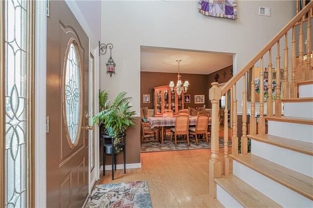 foyer entrance with hardwood / wood-style flooring and a notable chandelier