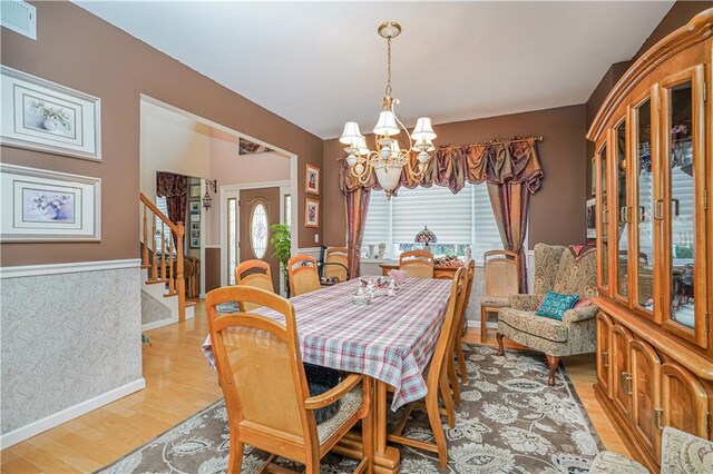 dining room featuring light wood-type flooring and a notable chandelier