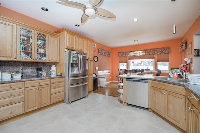 kitchen with stainless steel appliances, sink, tasteful backsplash, and decorative light fixtures