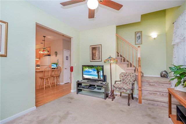 living area with ceiling fan and carpet flooring