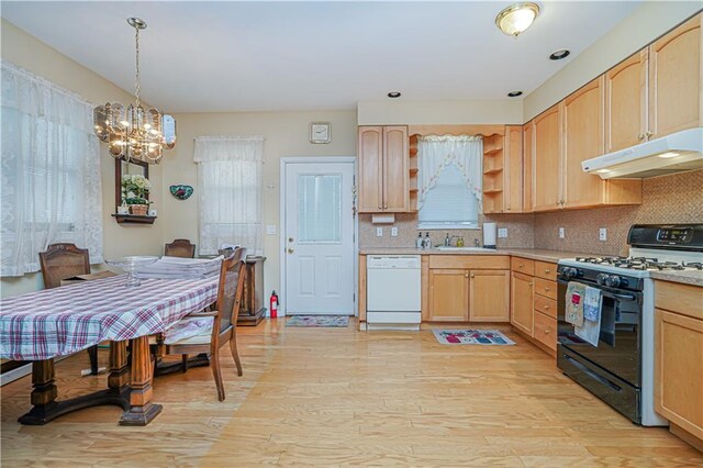 kitchen with dishwasher, light brown cabinets, black gas stove, a notable chandelier, and light hardwood / wood-style flooring