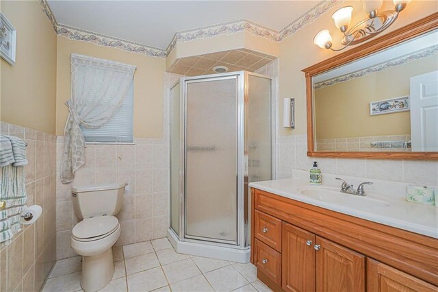 bathroom featuring an enclosed shower, tile patterned flooring, vanity, tile walls, and toilet