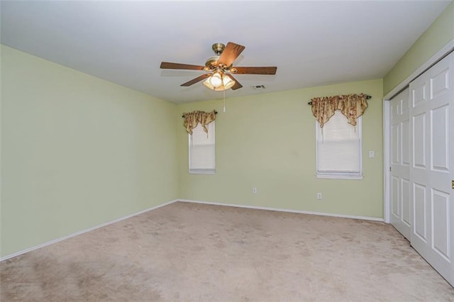 spare room featuring ceiling fan and light colored carpet