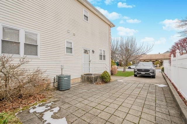 rear view of property featuring central AC unit and a patio area