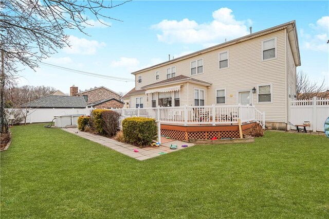 back of house with a pool side deck and a lawn